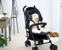 Toddler sat in the pushchair wearing a cream Star Fleece Baby Wrap Blanket | Pushchair Accessories - Clair de Lune UK