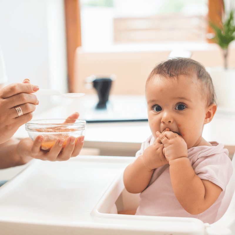 Baby sat in a 6in1 Play and Eat High Chair eating pureed food from a spoon | Feeding and Weaning | High Chairs - Clair de Lune UK