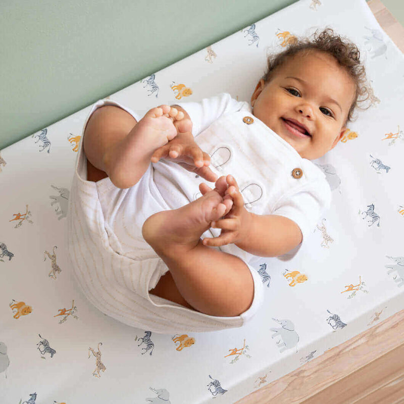 Happy baby holding their toes on the Clair de Lune Jungle Dream Anti-Roll Wedge Changing Mat | Explore Clair de Lune's Jungle Dream Collection - Clair de Lune UK