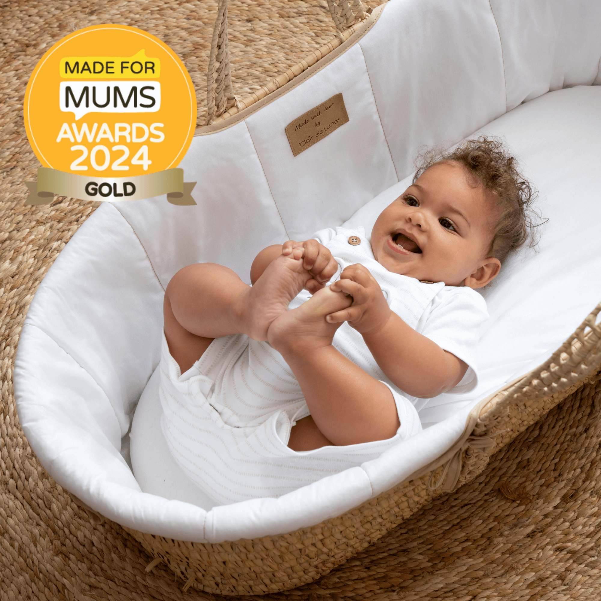 Baby lying in the award winning Organic Palm Moses basket while smiling and holding their toes | Moses Baskets and Bassinets | Buying Guide - Clair de Lune UK