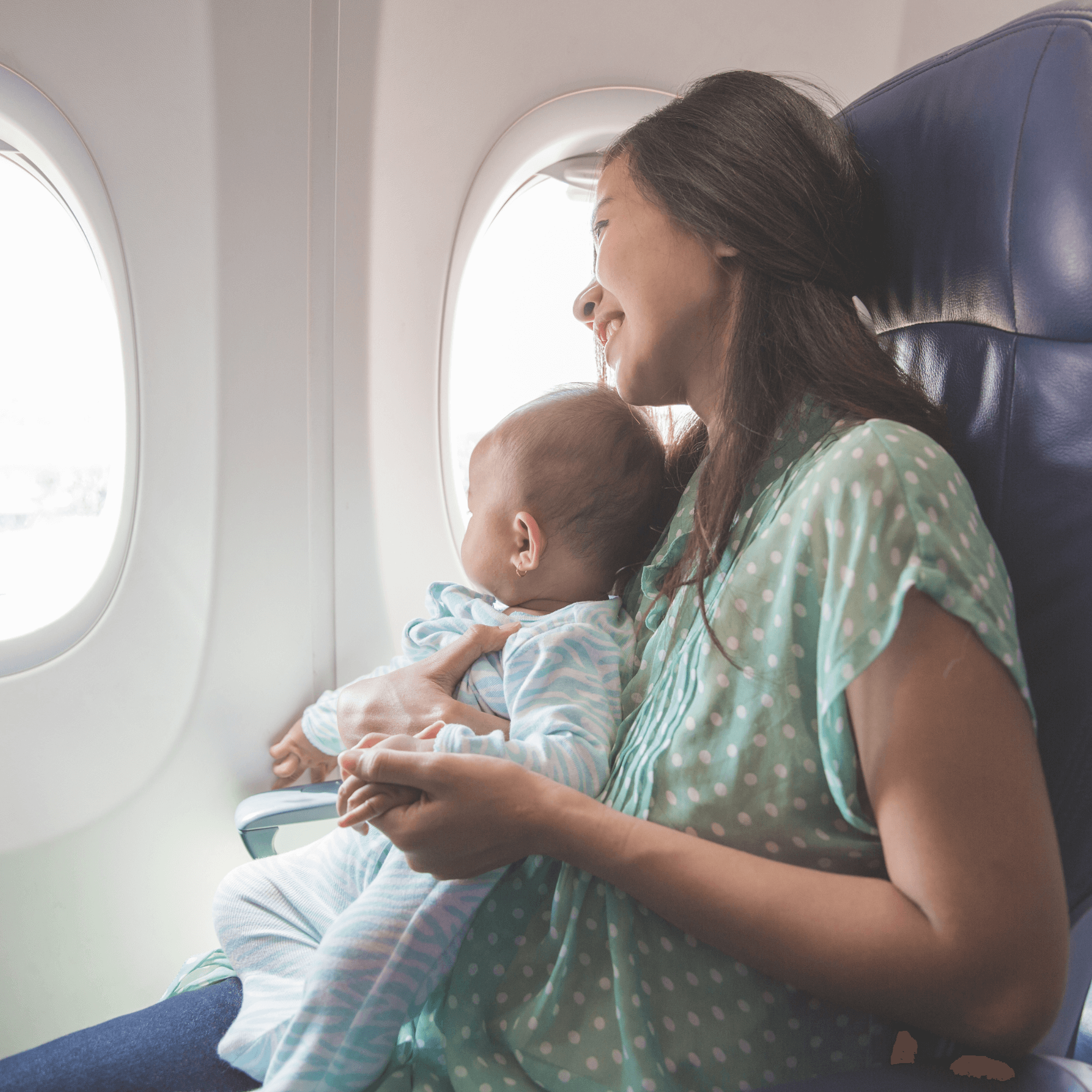 Mum sat on a plane in the window seat with her baby sat on her knee looking out at the sky | Travel with Baby | Summer Fun - Clair de Lune UK