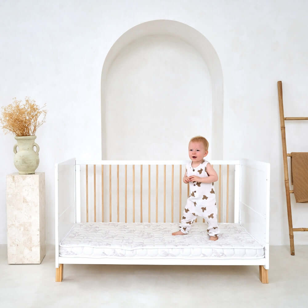 Toddler jumping on the mattress of the Essentials Cot Bed - Clair de Lune UK