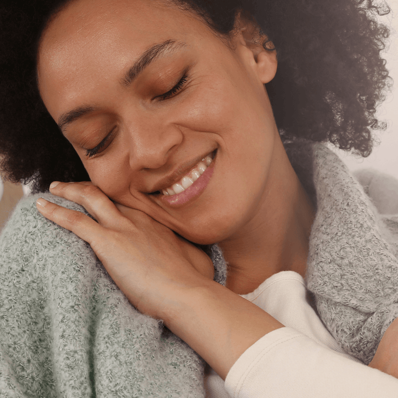 Mum resting her head on her shoulder smiling with her eyes closes | Post partum tips and advice - Clair de Lune UK