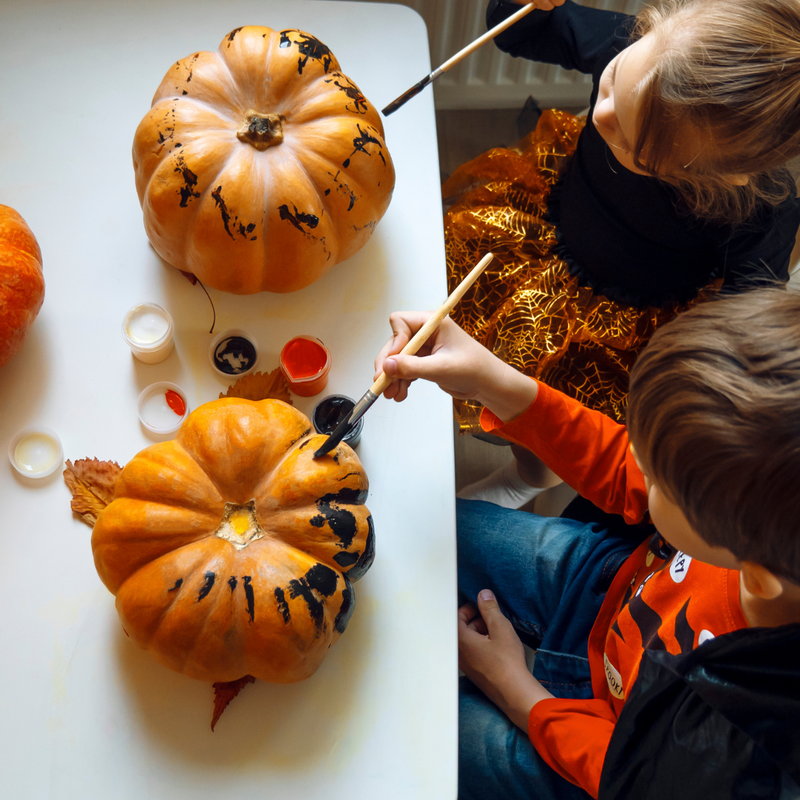 Two toddlers sat at the table painting their pumpkins | Messy Play - Clair de Lune UK