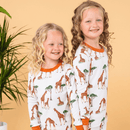 Two girls smiling wearing the Grow Grows Organic Gentle Giraffes Pyjamas | Organic Kids PJs and Nightwear - Clair de Lune UK