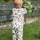 Child wearing the Grow Grows Organic Allotment Adventure Pyjamas while inspecting the vegetable patch | Organic Kids PJs and Nightwear - Clair de Lune UK