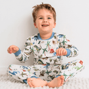 Boy sat laughing wearing the Grow Grows Organic Dandy Dinos Pyjamas | Organic Kids PJs and Nightwear - Clair de Lune UK