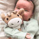 Close up of a baby holding the organic knitted GrowGrows Giraffe Comforter - Clair de Lune UK
