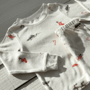 GrowGrows Organic Christmas Eve Pyjamas close up on the stockings, candy canes and Santas' sleigh | Organic Kids PJs and Nightwear - Clair de Lune UK