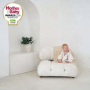 Toddler sitting on a white bean bag wearing Cream Star Fleece Baby Wrap Blanket for a winter walk - Mother & Baby Shortlist Award 2026 | Cosy Baby Blankets | Swaddle Blanket | Nursery Bedding - Clair de Lune UK