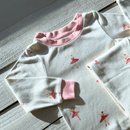 Grow Grows Organic Tiny Twirls Pyjamas folded on a wooden floor | Organic Kids PJs and Nightwear - Clair de Lune UK