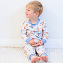 Boy sat leaning against a wall wearing the Grow Grows Organic Up, Up & Away Pyjamas | Organic Kids PJs and Nightwear - Clair de Lune UK