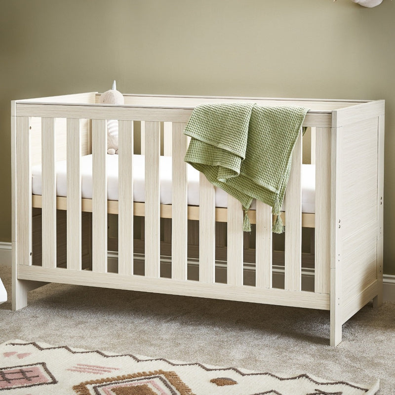 The cot bed of the Obaby Nika Oatmeal Cot Bed and Room Sets in a gender-neutral nursery room | Nursery Furniture Sets | Room Sets | Nursery Furniture - Clair de Lune UK