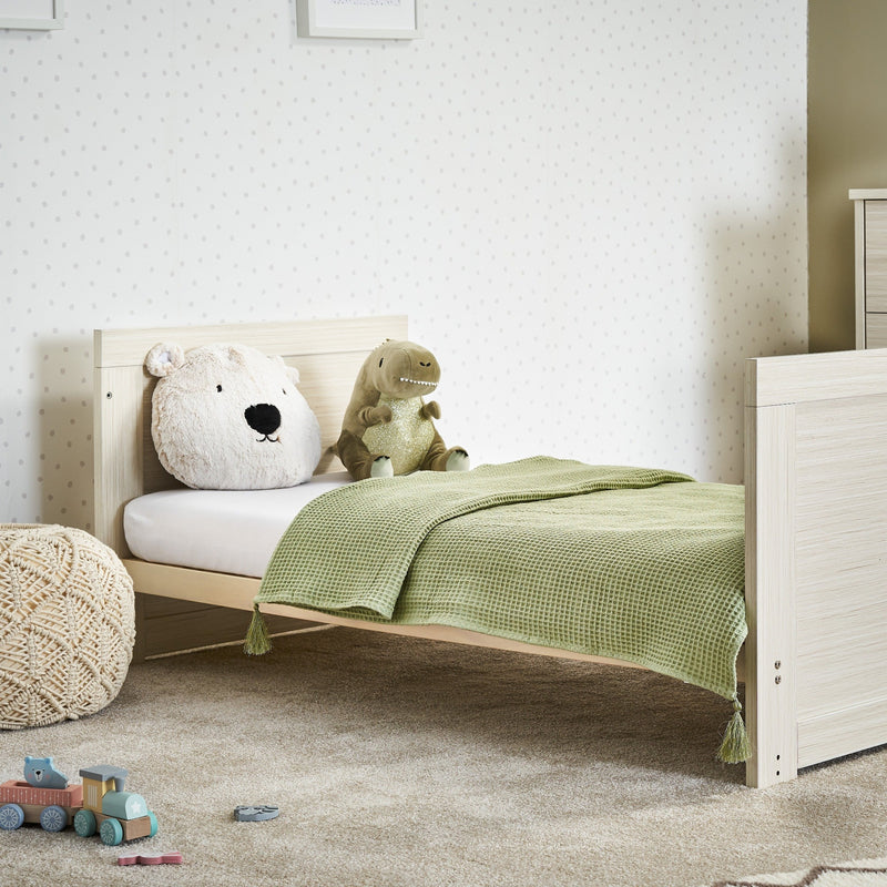 The cot bed of the Obaby Nika Oatmeal Cot Bed and Room Sets transformed to a toddler bed in a gender-neutral nursery room | Nursery Furniture Sets | Room Sets | Nursery Furniture - Clair de Lune UK