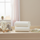Cream 2 Pack Cot Bed Sheet folded on a changing unit in the nursery | Soft Baby Sheets | Cot & Cot Bed Bedding | Nursery Linen - Clair de Lune UK