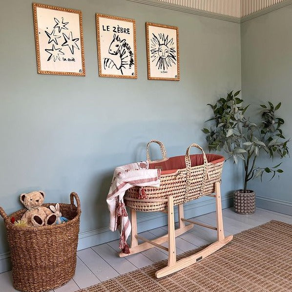 Rust Orange Organic Palm Moses Basket on a Natural Standard Rocking Stand taken by a customer in her Safari-inspired living room | Moses Baskets and Stands | Co-sleepers | Nursery Furniture - Clair de Lune UK