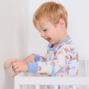Close up on a boy in  the cot wearing the Grow Grows Organic Up, Up & Away Pyjamas | Organic Kids PJs and Nightwear - Clair de Lune UK