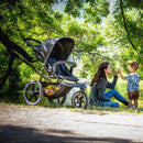 Mum and her baby on the river bank with her toddler son in the Hauck Runner 2 Pushchair | Baby Travel Essentials - Clair de Lune UK