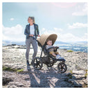 Mum pushing the Mocha Hauck Runner 2 Pushchair with her toddler in the stroller at the beach | Baby Travel Essentials - Clair de Lune UK