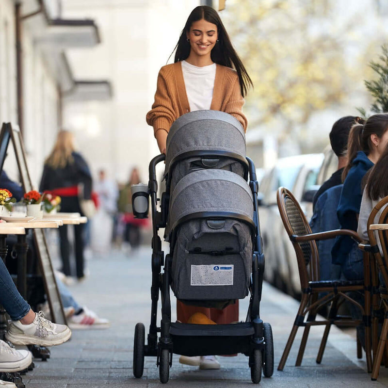 Mum walking with her Hauck Atlantic Twin Tandem Pushchair in the city centre | Strollers, Pushchairs & Prams | Baby Travel Essentials - Clair de Lune UK