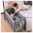 Newborn lying in the Dark Green Hauck Play N Relax Center by mum in a hotel | Travel Cots & Folding Cribs - Clair de Lune UK