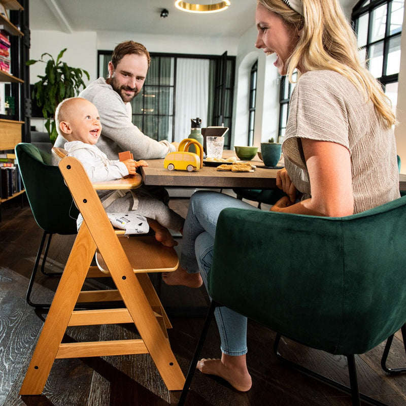 Mum and dad interacting with smiling toddler on the Hauck Alpha+ Wooden Highchair with Removable Front Bar in Natural | Highchairs | Feeding & Weaning - Clair de Lune UK