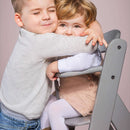 Toddlers cuddling on the Hauck Alpha+ Wooden Highchair | Baby Highchairs, stools and seats - Clair de Lune UK