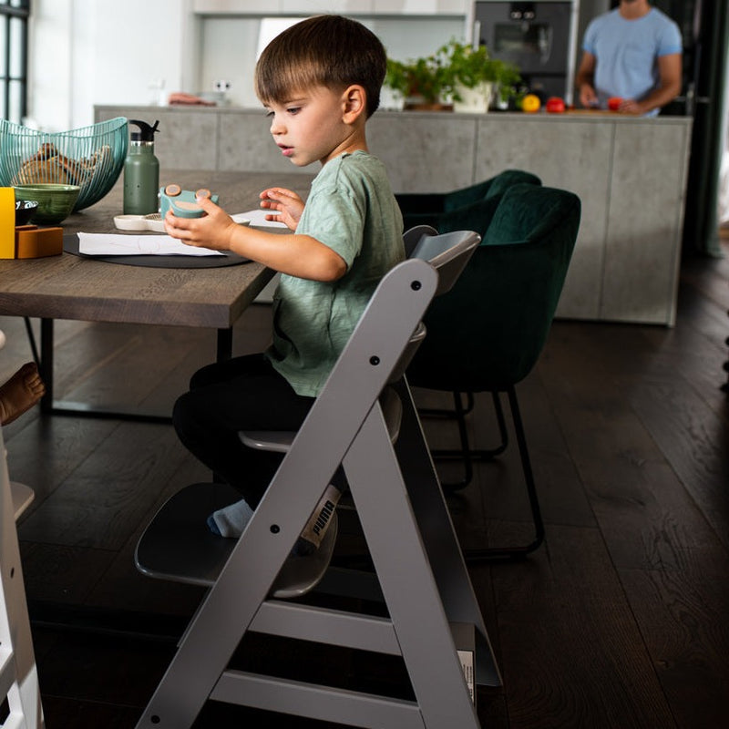 Little boy sitting on the Hauck Alpha+ Wooden Highchair with Removable Front Bar in Grey | Highchairs | Feeding & Weaning - Clair de Lune UK