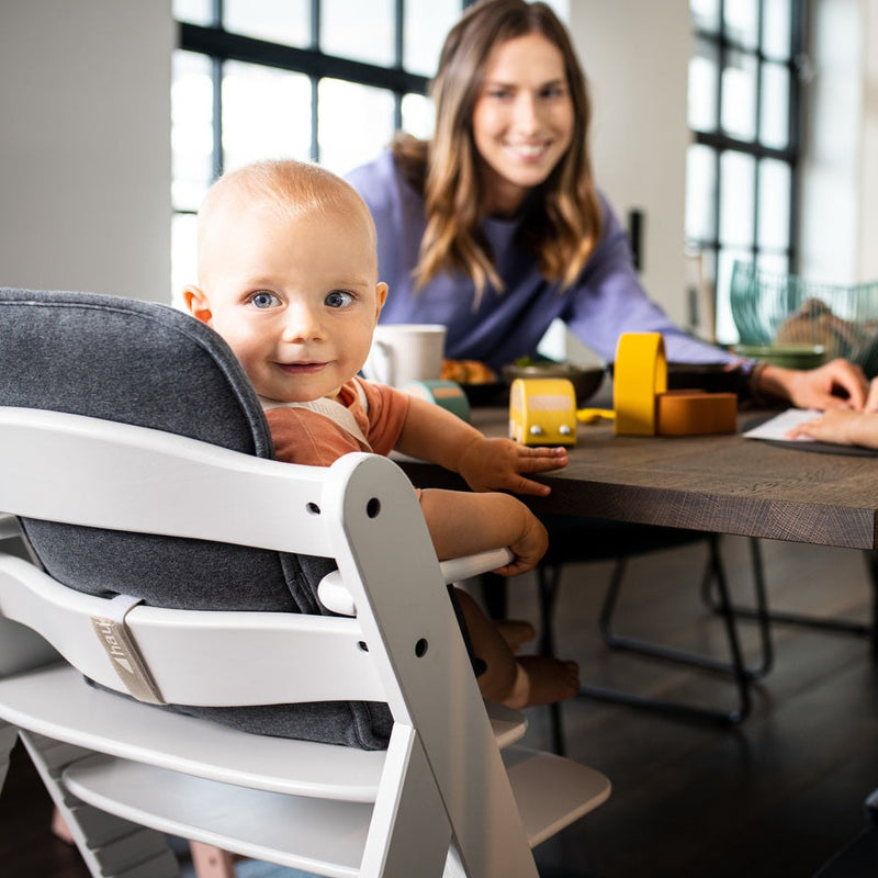 Toddler sitting on the Hauck Alpha+ Wooden Highchair with Removable Front Bar in White | Highchairs | Feeding & Weaning - Clair de Lune UK