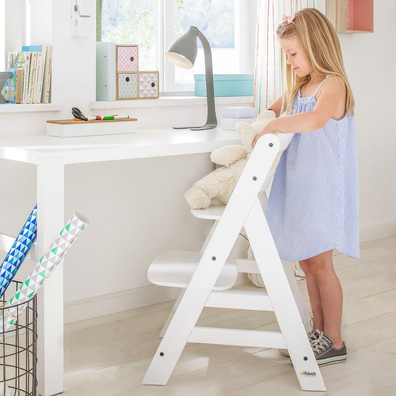 Little girl using her Hauck Alpha+ Wooden Highchair with Removable Front Bar in White as a study chair | Highchairs | Feeding & Weaning - Clair de Lune UK