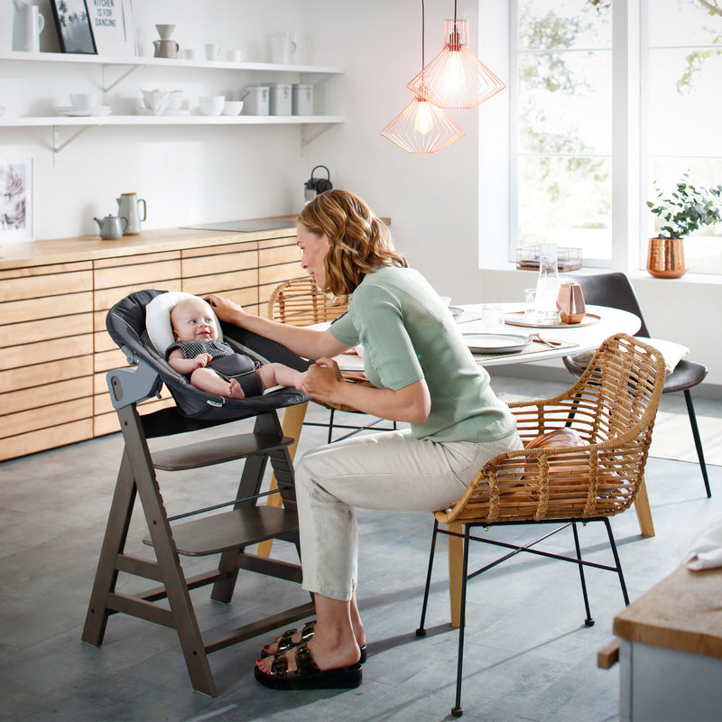 Mom feeding baby sitting on the Hauck Alpha+ Bouncer and High Chair Bundle | Highchairs | Feeding & Weaning - Clair de Lune UK