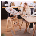 Mum attending to her baby in the Hauck Highchair Bouncer Eco in the kitchen with additional attachement | Baby Bouncers and High Chairs - Clair de Lune UK