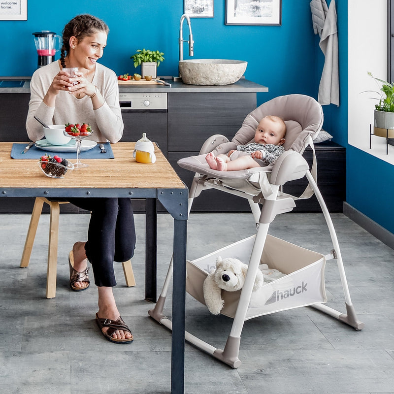 Mum enjoying her lunch next to her newborn playing on the Stretch Grey Hauck Travel 3in1 Sit N Relax High Chair & Bouncer | Highchairs | Feeding & Weaning - Clair de Lune UK