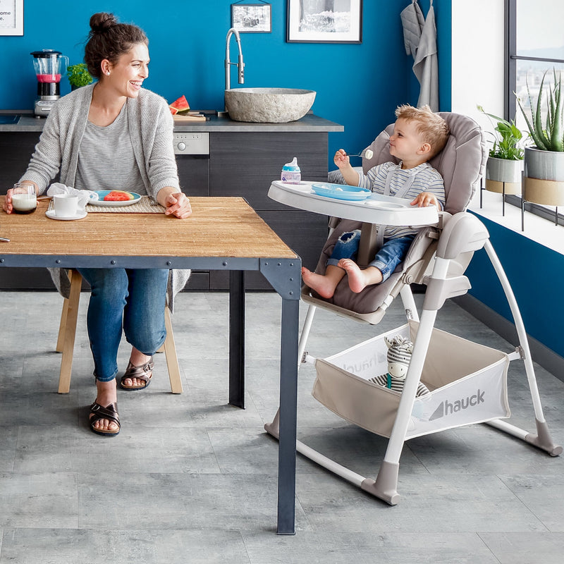 Mum enjoying her lunch next to her toddler eating on his Stretch Grey Hauck Travel 3in1 Sit N Relax High Chair & Bouncer | Highchairs | Feeding & Weaning - Clair de Lune UK
