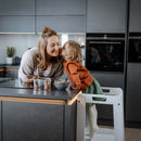 Toddler girl kissing her mum in the white Hauck Learn N Explore Learning Tower | Feeding & Weaning | Montessori Furniture For Babies & Toddlers - Clair de Lune UK