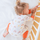 Baby girl sleeping in her cot wearing the GrowGrows Organic Radiant Rainbows Sleepsuit | Baby Grows and Onesies | Organic Baby Clothes - Clair de Lune UK