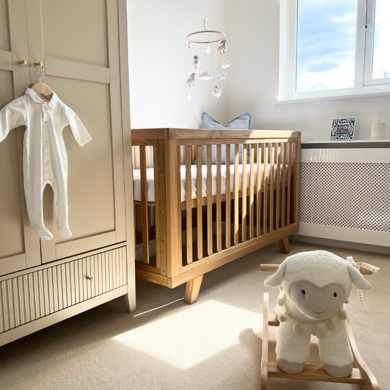 Oak Cot Bed in beige nursery next to a childs wardrobe | Cot, Cot Beds and Toddler Beds | Nursery Furniture - Clair de Lune UK