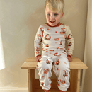 Boy wearing Grow Grows Organic Fluffy Foxes Pyjamas sat on a wooden stool | Organic Kids PJs and Nightwear - Clair de Lune UK