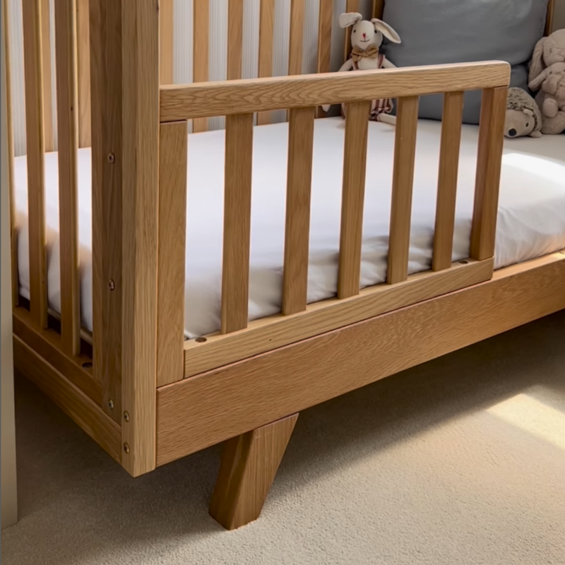 Close up of the Oak Cot Bed Extension KitClose up of Oak Cot Bed Extension Kit converted to a toddler bed in neutral nursery | Cots, Cot Beds, Toddler & Kid Beds | Nursery Furniture - Clair de Lune UK