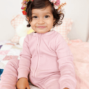 Toddler wearing the Blush Grow Grows Organic Ribbed Baby Sleepsuit in a brightly light nursery | Baby Sleep Wear | Children's pyjamas - Clair de Lune UK