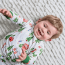 Toddler lay down laughing wearing the GrowGrows Organic Alpine Adventures Pyjamas | Organic Kids PJs and Nightwear - Clair de Lune UK