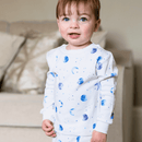 Girl wearing the Grow Grows Organic Marvellous Moons Pyjamas in a living room setting | Organic Kids PJs and Nightwear - Clair de Lune UK