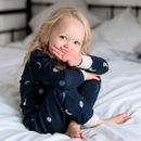 Girl sat on the bed wearing the Grow Grows Organic Midnight Moons Pyjamas | Organic Kids PJs and Nightwear - Clair de Lune UK