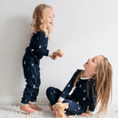 Two girls playing on the floor wearing matching Grow Grows Organic Midnight Moons Pyjamas | Organic Kids PJs and Nightwear - Clair de Lune UK