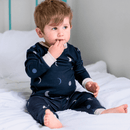 Boy sat on the bed wearing the Grow Grows Organic Midnight Moons Pyjamas | Organic Kids PJs and Nightwear - Clair de Lune UK