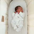 Curled up newborn baby lying in the Cream Organic Palm Moses Basket in a white onesie | Moses Baby Baskets & bassinets | Nursery Furniture | Organic Baby Product - Clair de Lune UK