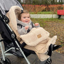 Toddler snuggling in the Beige Snug Universal Pushchair Footmuff | Pushchair Cosytoes & Footmuffs | Travel Accessories - Clair de Lune UK