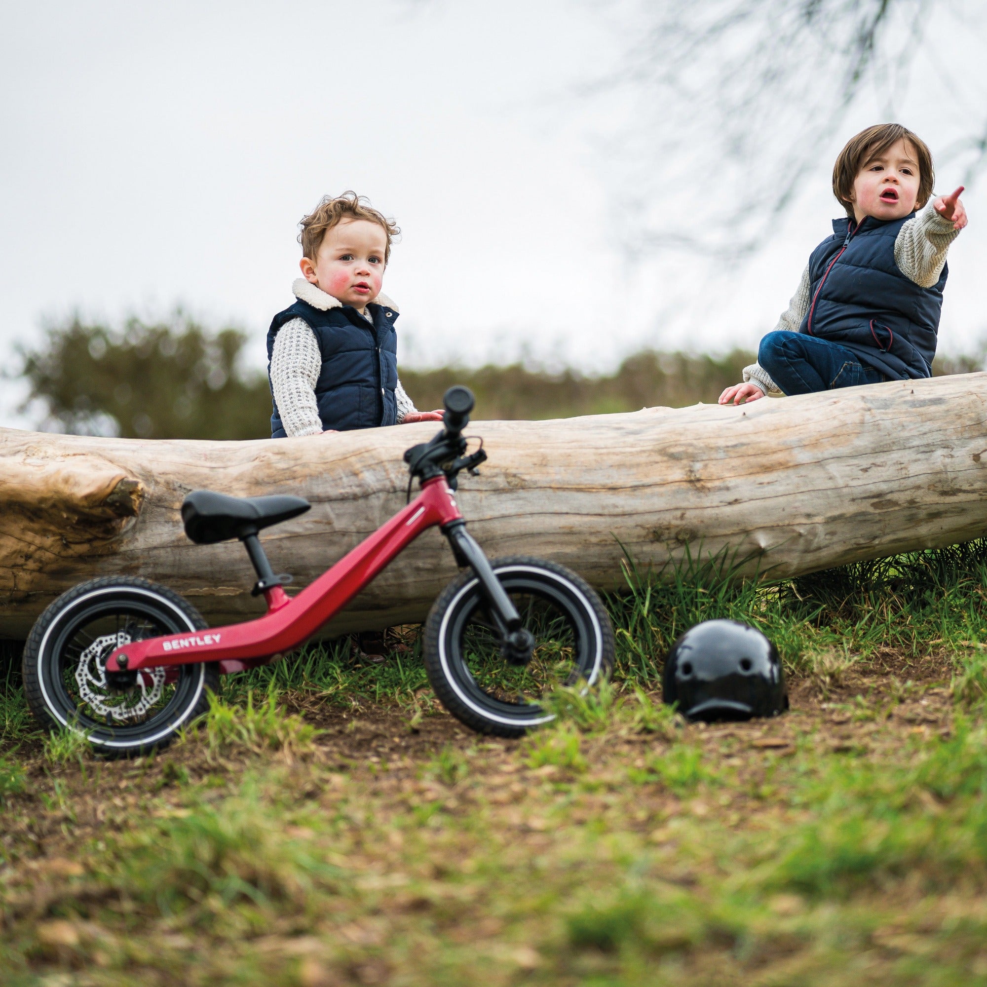 Boys resting near a log after riding their Bentley Balance Bikes | Toddler Bikes | Montessori Activities For Babies & Kids - Clair de Lune UK