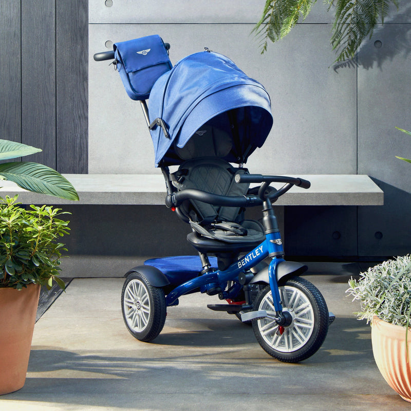 The side of the Sequin Blue Bentley 6in1 Trike - Convertible Baby Stroller with the hood in a garden | Strollers, Pushchairs & Prams | Pushchairs, Carrycots & Car Seats Baby | Travel Essentials - Clair de Lune UK