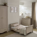 Cashmere Clara cot bed converted into a toddler bed with matching wardrobe and changer, part of the CuddleCo Clara 3 Piece Nursery Furniture Set in a cosy neutral nursery | Nursery Furniture | Cot Bed - Clair de Lune UK